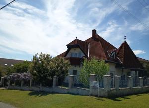 a house with a fence in front of it at Balaton White House in Vonyarcvashegy