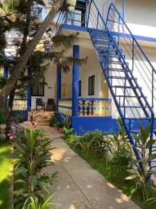 a house with a blue staircase in front of it at Anthony Stays Anjuna in Anjuna +6 photos
