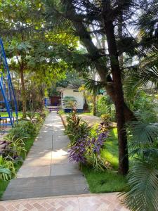 a walkway in a garden with trees and flowers at Anthony Stays Anjuna in Anjuna