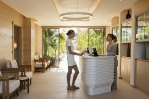 two women standing at a counter in a hotel lobby at Mitsis Faliraki in Faliraki +75 photos