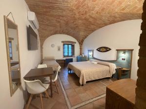 a bedroom with two beds and a table in a room at Bed & Breakfast Casale Gregoriano in San Gimignano +158 photos