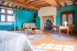 a bedroom with a bed and a table and a fireplace at Château du Hardas in Segré