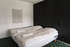 a bed in a room with a black wall at Faxe Ladeplads Motel in Hylleholt