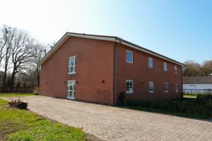 a large red brick building on a brick road at Faxe Ladeplads Motel in Hylleholt