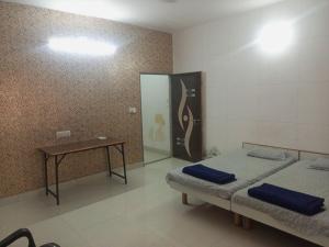 a room with two beds and a table in it at Madhav Villa Only Family in Dwarka