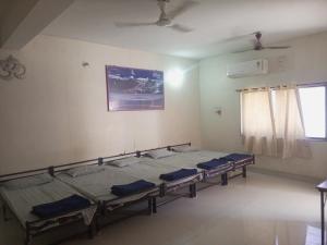 a room with four beds in it with a window at Madhav Villa Only Family in Dwarka +2 photos