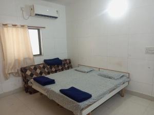 a room with a bed and a couch with blue pillows at Madhav Villa Only Family in Dwarka