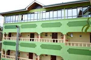 a green building with plants on the balconies at Greenvale Hotel 1BR Along Kamiti Road in Kiambu