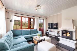 a living room with a blue couch and a fireplace at Rauland Feriesenter in Rauland