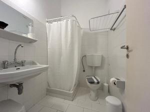 a white bathroom with a toilet and a sink at Tinion Hotel in Tinos +28 photos