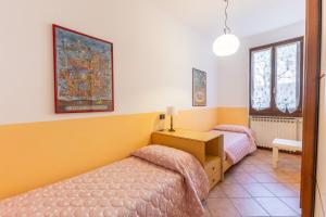a bedroom with two beds and a table and two windows at TINA HOME LAKE VIEW in Garda
