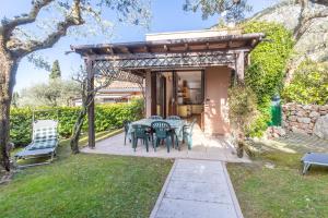 a patio with a table and chairs in a yard at TINA HOME LAKE VIEW in Garda