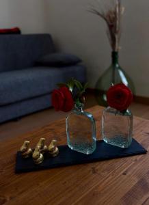 two glass vases with roses on a table at 31 civico in Molini di Triora