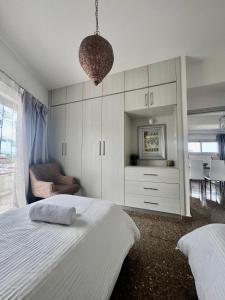 a bedroom with a large white bed and a chair at GA apartments in Kato Pyrgos