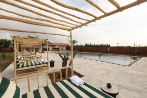 a patio with a bed and a swimming pool at Bohemian lodge guest house in Aït Namous