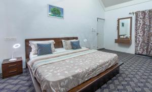 a bedroom with a large bed and a mirror at Gaash Cottages in Buna Palang