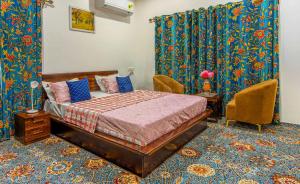 a bedroom with a bed and chairs in a room at Gaash Cottages in Buna Palang