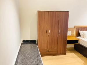 a bedroom with a wooden cabinet next to a bed at Origin Suites Luxury Boutique Hotel Pushkar in Pushkar +3 photos