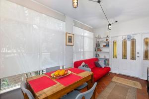 a living room with a table and a red couch at Family stay minute walk from Hargraves beach in Norah