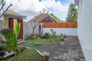 a courtyard with a house with a fence at Patera Living in Sempidi