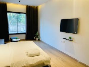 a bedroom with a bed and a flat screen tv at Origin Suites Luxury Boutique Hotel Pushkar in Pushkar