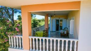 a front porch of a house with a white railing at Charming Country House Just Steps from Everything in Kyparissia