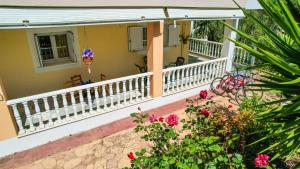 a balcony of a house with flowers and plants at Charming Country House Just Steps from Everything in Kyparissia