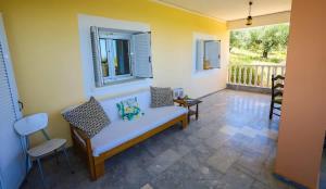 a living room with a bench and a window at Charming Country House Just Steps from Everything in Kyparissia