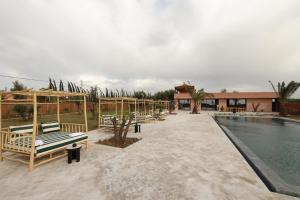 a swimming pool with lounge chairs next to a resort at Bohemian lodge guest house in Aït Namous