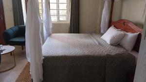 a bedroom with a large bed and a window at summeroasishotet in Kitui