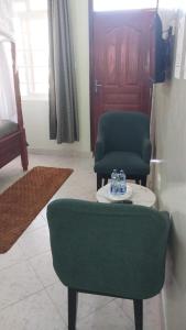 a living room with two chairs and a table at summeroasishotet in Kitui