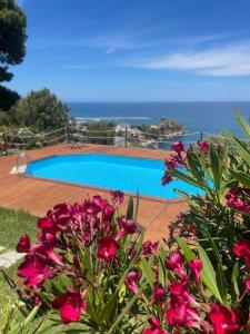 a view of a swimming pool with pink flowers at Villa Magarà in Cefalù