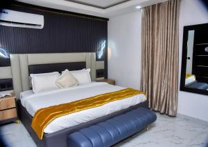 a bedroom with a large bed and a mirror at Orchid - Bliss Hotels in Lagos +11 photos