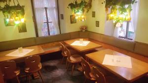a restaurant with wooden tables and chairs and windows at Hotel Restaurant Krone in Bad Brückenau