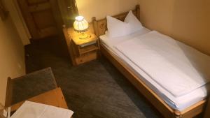 a bedroom with a bed and a lamp on a table at Hotel Restaurant Krone in Bad Brückenau