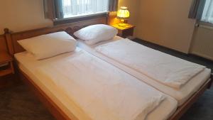 two beds with white sheets and pillows in a bedroom at Hotel Restaurant Krone in Bad Brückenau