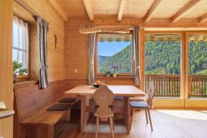 a dining room with a table and a large window at Ferienhaus Schwarzenbach in San Genesio Atesino