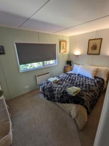 a bedroom with a large bed with a window at Nyth y Dryw in Machynlleth