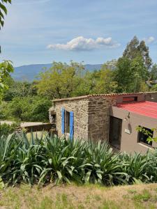a stone house with blue doors in a yard at Entrerobles - Casiña Cereixa in La Cañiza +62 photos