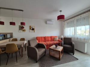 a living room with a couch and chairs and a table at Noémi Wellness Apartman in Siófok