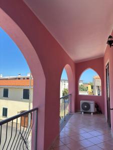 a balcony with two arches and a tv at Appartamento Rosa in Orosei +6 photos