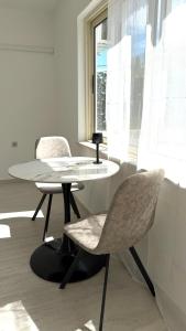 zwei Stühle und ein Tisch in einem Zimmer mit Fenster in der Unterkunft Studio Perina in Trogir