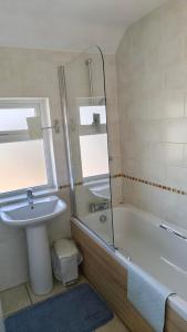 a bathroom with a sink and a tub and a mirror at 15 Aller Park Rd, Newton Abbot in Newton Abbot +18 photos