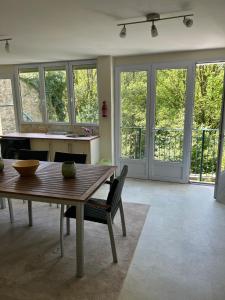 a living room with a wooden table and glass doors at repos en forêt in Huelgoat