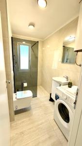 ein Badezimmer mit Waschmaschine und Waschbecken in der Unterkunft Studio Perina in Trogir
