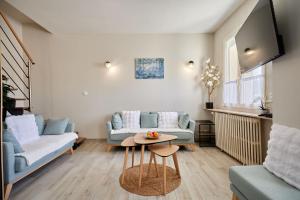 a living room with a couch and a table at La Parenthese - Charme & Coeur Historique in Bayeux