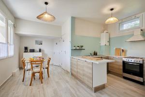 a kitchen with a table and chairs in it at La Parenthese - Charme & Coeur Historique in Bayeux