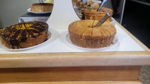 three cakes sitting on plates on a counter at Grand Hotel Taboao in Taboão da Serra