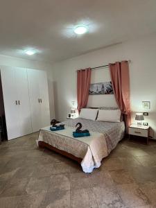 a bedroom with a bed with two shoes on it at Appartamento Rosa in Orosei