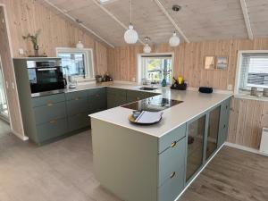 a kitchen with blue cabinets and a white counter top at Udsigten over Hjarbæk in Løgstrup